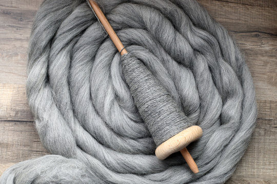 Handspindel auf grauem Kammzug zum Spinnen