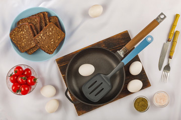 Cooking breakfast. Eggs, cherry tomatoes and dark bread cereal. Eco food.