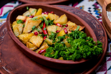Fried potatoes with pieces of meat in a clay pot. European cuisine.