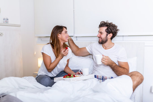 Romantic breakfast in bed man prepare for his woman, she was very happy, Young beautiful couple in bed having a breakfast and coffee in bed. Young couple having romantic breakfast in bed.