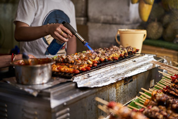 Street food chef is heating food at a night market in Bangkok, Thailand