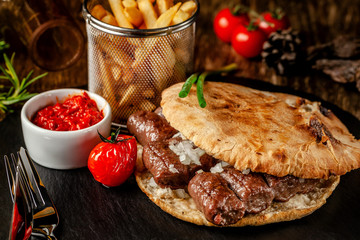 Turkish, oriental cuisine. Turkish tortilla, bun, pita bread with kebab and pickled onions. Serving...