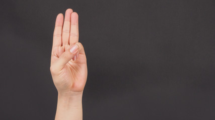 A hand sign of 3 fingers point upward meaning three, third or use in protest.It put on black backgroud