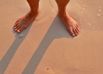 Feet on the beach at sunrise