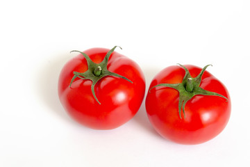 A ripe red tomato with water drops isolated on a white background сlose up.