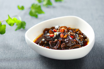 Cold black fungus with vinegar and chili in a white ceramic dish