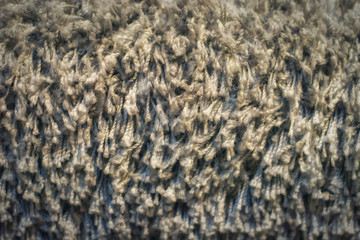 Texture of long-pile carpet. Abstract background of a shaggy grey carpet pile texture with long fibers.