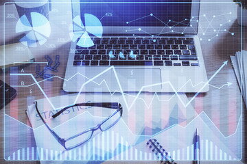 Double exposure of chart and financial info and work space with computer background. Concept of...
