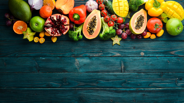 Fruits and vegetables on blue wooden background. Food background. Top view. Free space for your text.