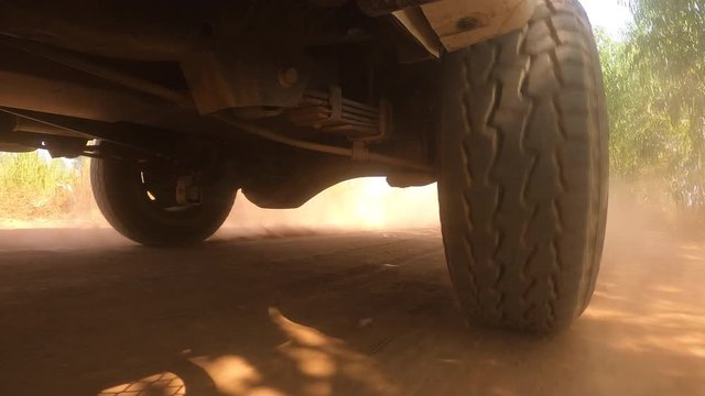 The rear wheels powertrain system of the 4 wheels off road drive light truck driving on dirt and dust ground