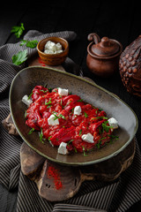 National Appetizer of sweet pepper in tomato sauce with feta cheese. Restaurant menu. Background black boards.