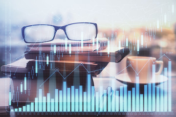 Financial graph hologram with glasses on the table background. Concept of business. Double exposure.