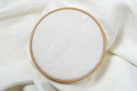 Closeup of wooden embroidery hoop and clean white fabric for hobby needlework.Empty space for design. Template for hobby design