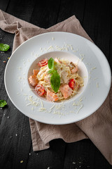 Pasta with seafood, salmon, cream sauce and cherry tomatoes.