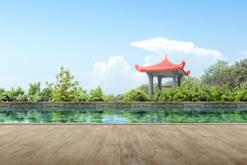 Obraz premium Wooden path with Chinese gazebo building with pond and trees