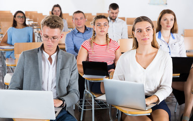Group of people with laptops in lecture hall