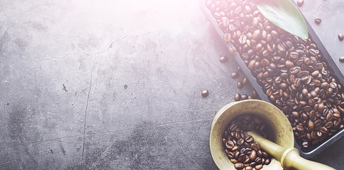 Coffee beans with green leaves for cooking. Bag of coffee. Coffee beans roasted on the table.