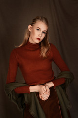 girl in a beautiful brown fur coat posing in the Studio on a brown background