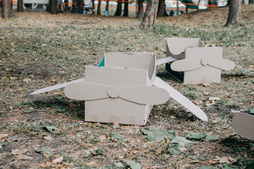 Upcycling ideas, Recycle crafts. Toy airplane made from cardboard boxes on grass. DIY Creative cardboard paper ideas for children