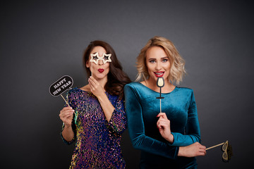 Portrait of playful women with photo booth partying