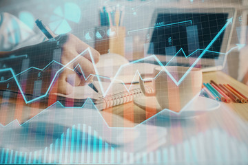 Financial chart drawn over hands taking notes background. Concept of research. Double exposure