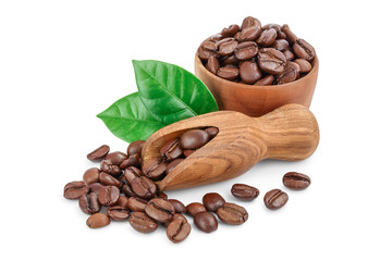 Heap of roasted coffee beans in wooden bowl and scoop with leaves isolated on white background.