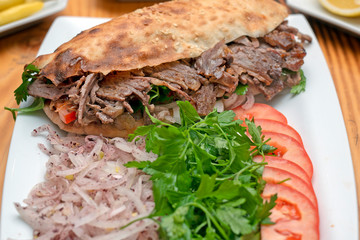 close up of kebab sandwich on wooden background