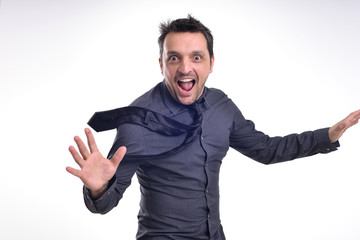 Fototapeta premium Portrait of a young dude isolated on white, wearing a grey shirt and a black tie acting excited, surprised, pulling faces .