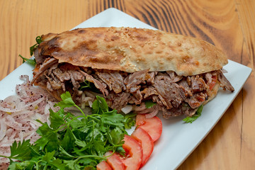close up of kebab sandwich on wooden background