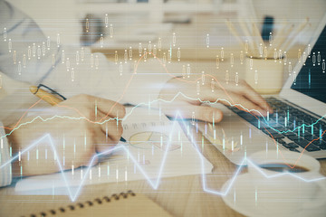 Multi exposure of stock market graph with man working on laptop on background. Concept of financial analysis.