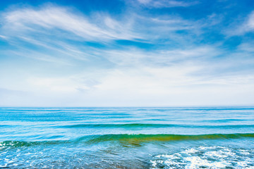 Obraz premium Blue sea water with waves, foam and white clouds on the sky. Calm tropical landscape