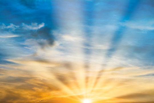 Beautiful dramatic sunset with sun rays and clouds
