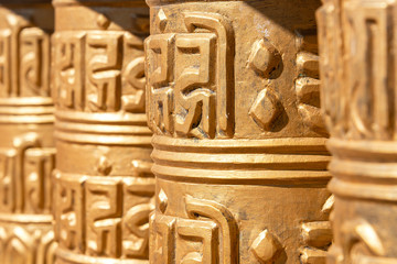 Praying drums. Line of vintage copper praying drums with sanskrit symbols.