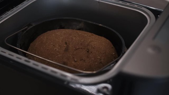Close Up Of Lid Of Bread Making Machine Being Opened With Fresh Brown Bread Inside 