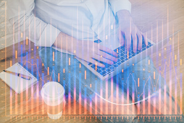 Forex graph with businessman working on computer in office on background. Concept of analysis. Double exposure.