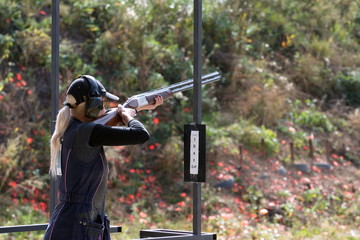 Shooter from a gun practicing shooting on plates in nature