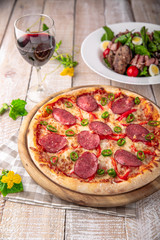 Tasty hot italian pizza Grand Pepperoni with Mozzarella, Tomato Sauce, Pepperoni on old wooden table. Pizzeria menu. Concept poster for Restaurants or pizzerias