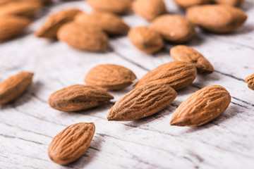 Almonds nut on white wooden table. Almond healthy raw food.