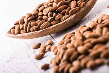 Almonds nut on white wooden table. Almond healthy raw food.