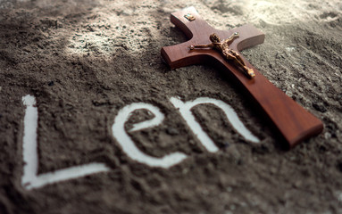 Lent word written in ash and christian cross as a T letter a religion concept Ash wednesday