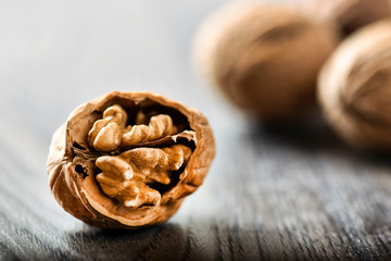 Whole walnuts on dark board, Walnut kernels in wood rustic bowl.