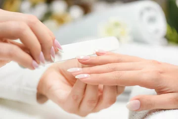 Foto op Aluminium Nagels manicure met vijl. Vrouw mooie nagelverzorging. na het vullen. © Milan