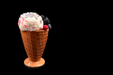 Ice cream with blueberries, blackberries and raspberries on a black background.  Copy space.
