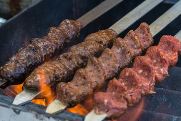 Adana kebab (ground lamb minced meat on skewer on grill over charcoal).Chef preparing traditional authentic Turkish shaworma. Middle eastern cuisine. Handmade specialty street food market with spices