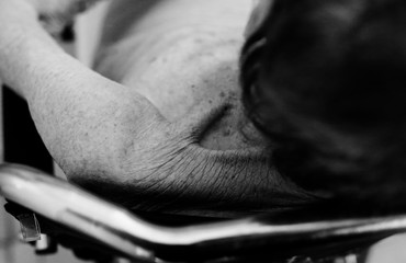 Aged woman sitting in wheelchair. wrinkle skin.