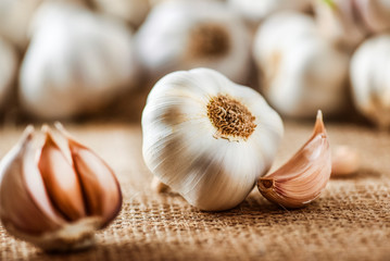 Garlic clove and bulb in wooden basket vintage background.