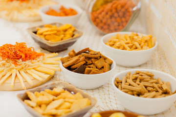 A lots of salty snacks on a table, many cheese and crackers on the table with snacks