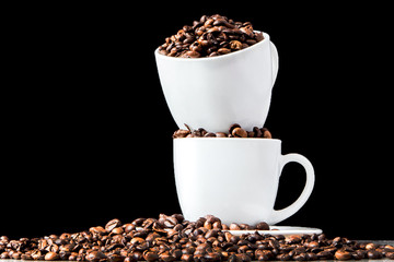 Black coffee in white cup and coffee beans on black background. Top view, space for text