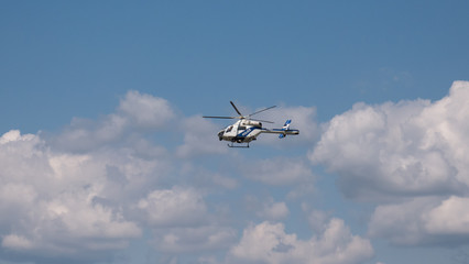 blue and white police helicopter flying in the sky