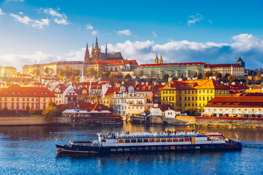 Fototapeta Prague Castle, Charles Bridge and boats on the Vltava river. View of Hradcany Prague Castle, Charles Bridge and a boats on the Vltava river in the capital of the Czechia. Boat cruise on Vltava river.